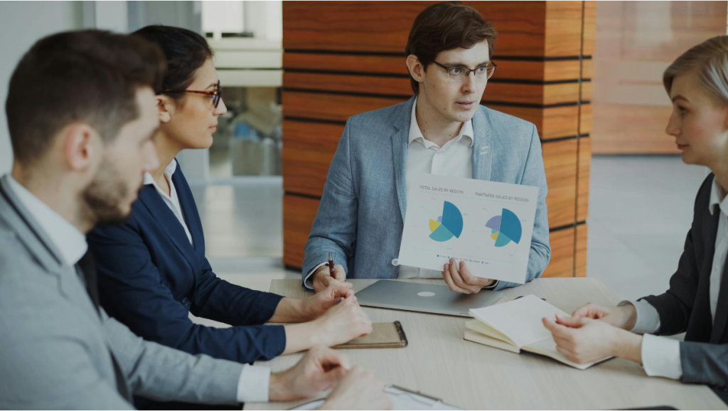 Advisor reviewing service business sale timeline charts with two owners in a meeting