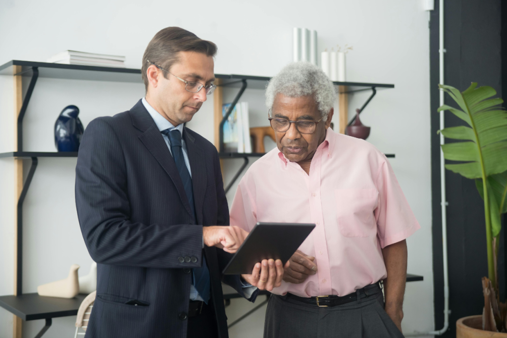 Strategic acquirer reviewing HVAC company financials on a tablet with the owner in an office