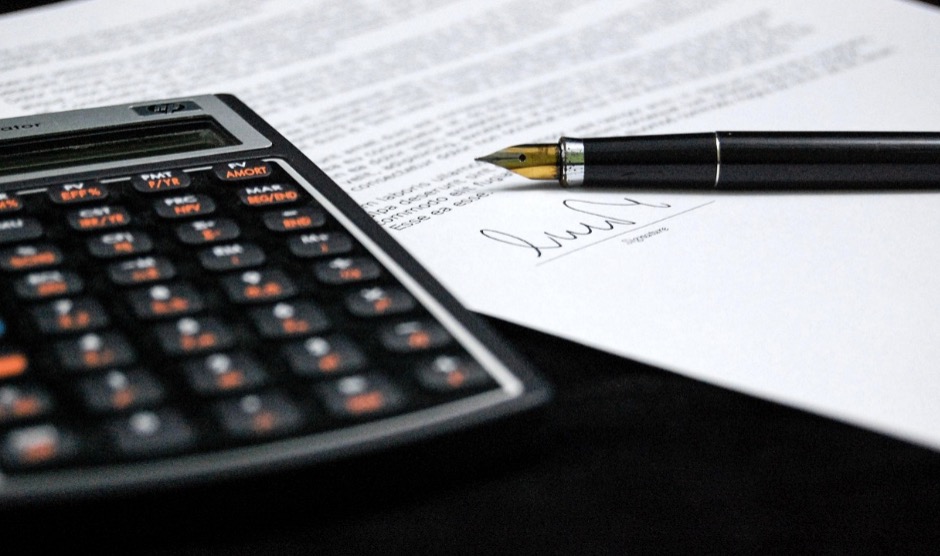 A calculator and a document are being used to calculate the EBITDA multiples for a plumbing business