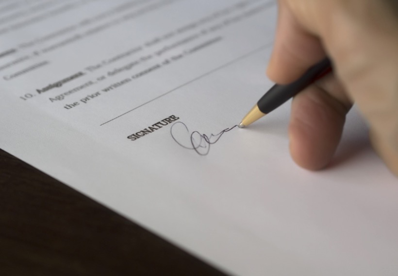 A businessman signing a contract after selling his business.