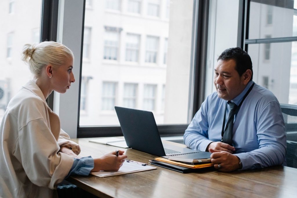 Business owner and advisor discussing valuation metrics during a meeting at a conference table