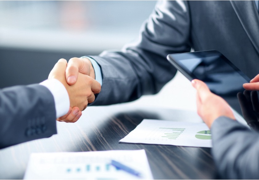 Two business professionals agreeing on the sale of a business.