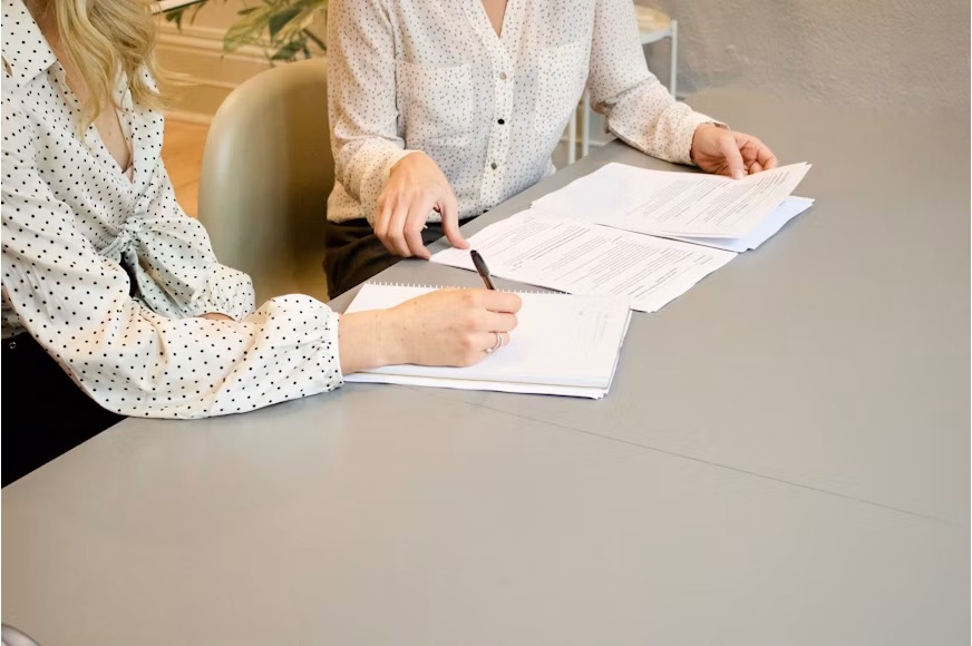 Business owner reviewing financial documents at a desk with an advisor