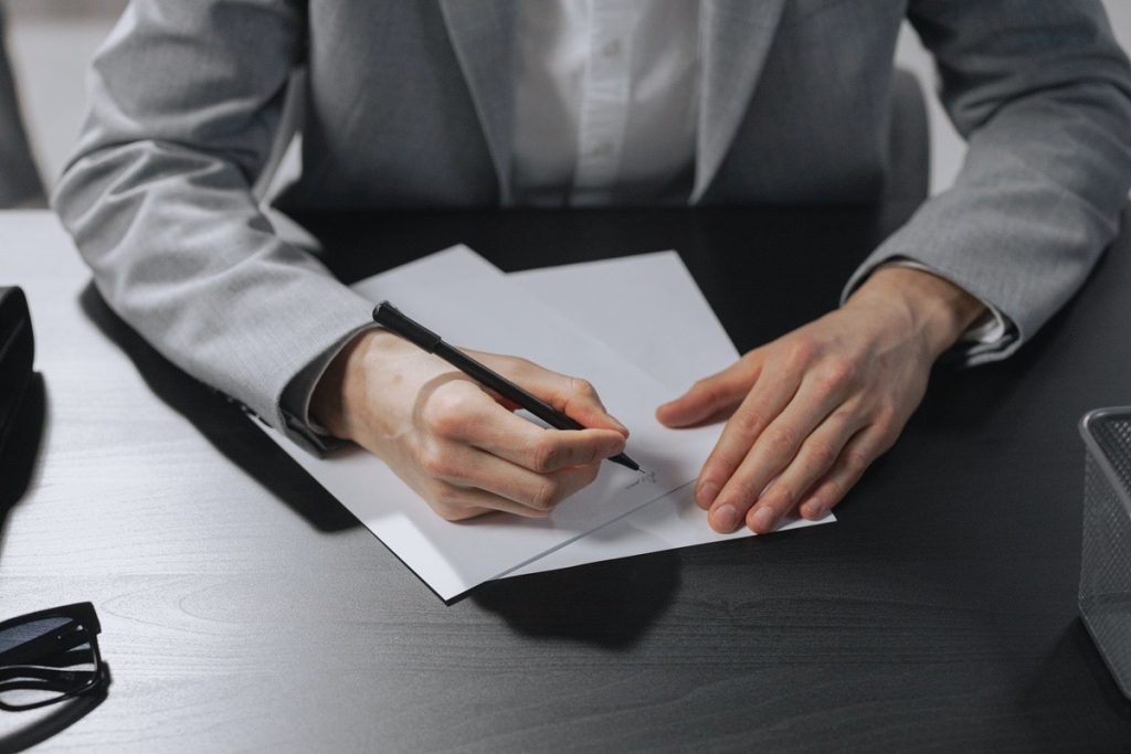 A person signing seller financing legal documents at a desk