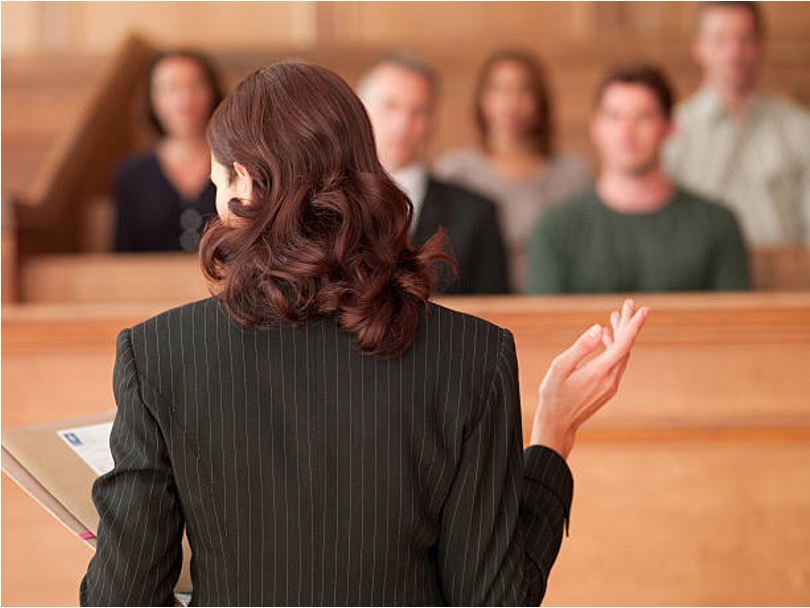 Attorney addressing a jury in a courtroom, arguing whether a business sale non-compete is reasonable