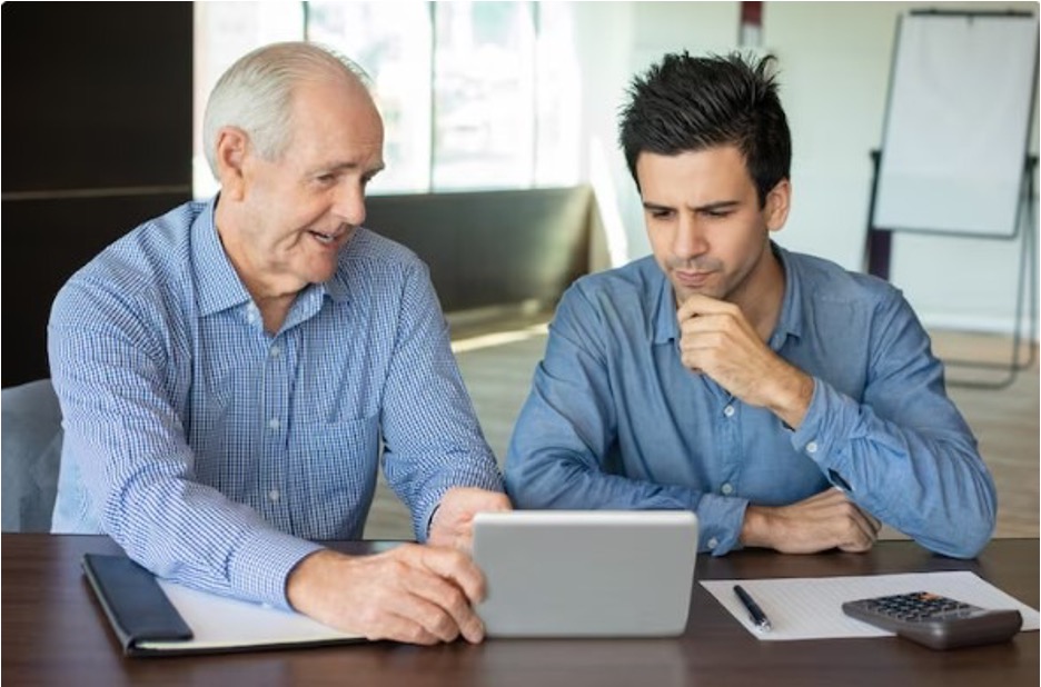 Two businessmen reviewing data on a tablet in an office setting